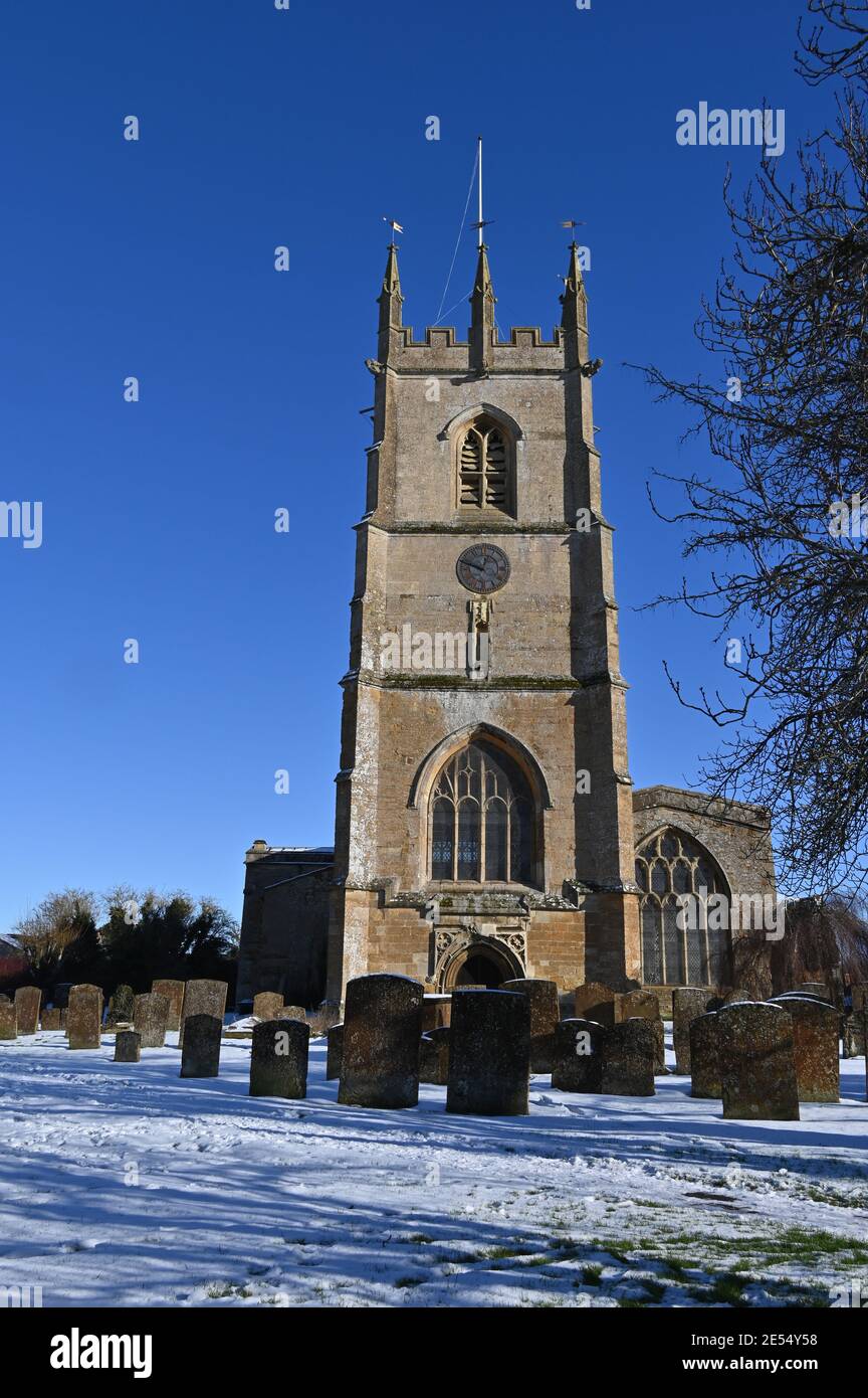 Vista de la iglesia parroquial de San Pedro en el north Oxfordshire pueblo de Hook Norton después de una Nevada día anterior Foto de stock