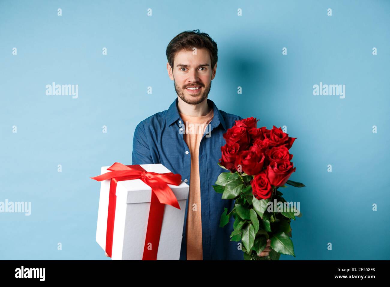 El concepto del día de San Valentín. Hombre soñando con el amor verdadero,  sosteniendo un corte de corazón rojo y parado cerca de globos románticos,  fondo azul Fotografía de stock - Alamy