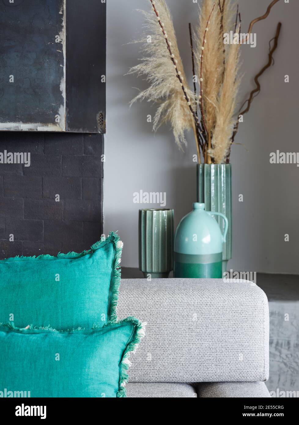 salón interior con sofá cojines y jarrones de color gris y turquesa, jarrón  con plumas Fotografía de stock - Alamy