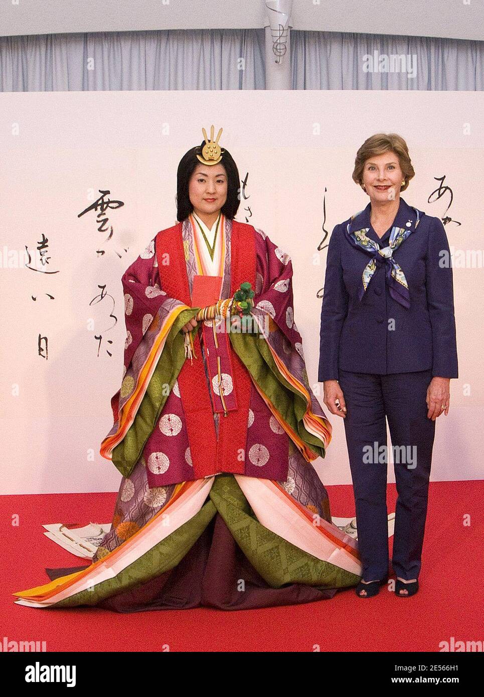 La primera dama ESTADOUNIDENSE Laura Bush (R) posan con una mujer japonesa  vestida con un antiguo kimono durante una demostración del antiguo kimono  de 12 capas en el primer día oficial de