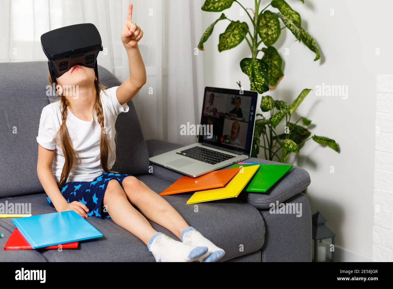 Probar nuevas tecnologías. Pequeña colegiala usando grandes gafas VR siendo  impresionado jugando juegos virtuales. Escuela en casa, educación en línea,  educación en el hogar Fotografía de stock - Alamy