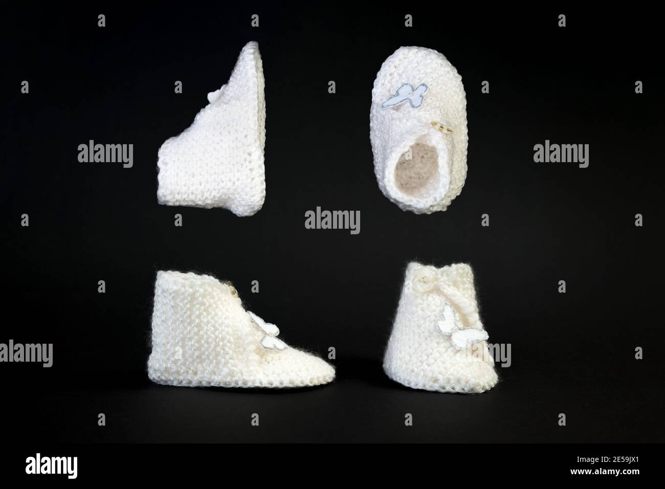 de zapatos blancos de punto hechos a mano para niños pequeños. Adorable bebé recién nacido zapatos aislados sobre fondo negro Fotografía stock - Alamy