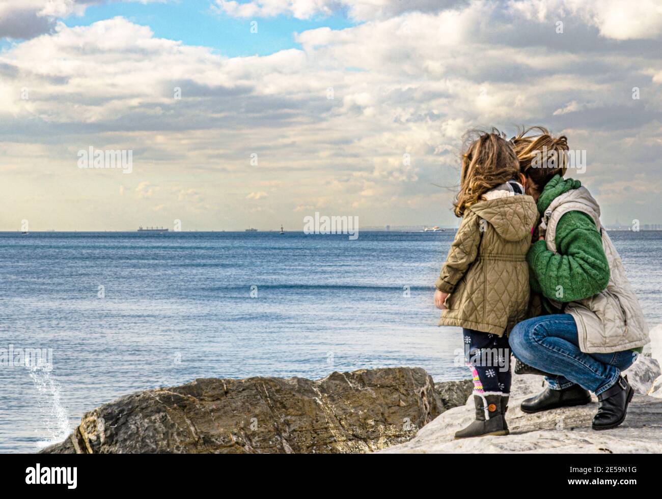 Mirando lejos, madre e hija, costa del océano Foto de stock
