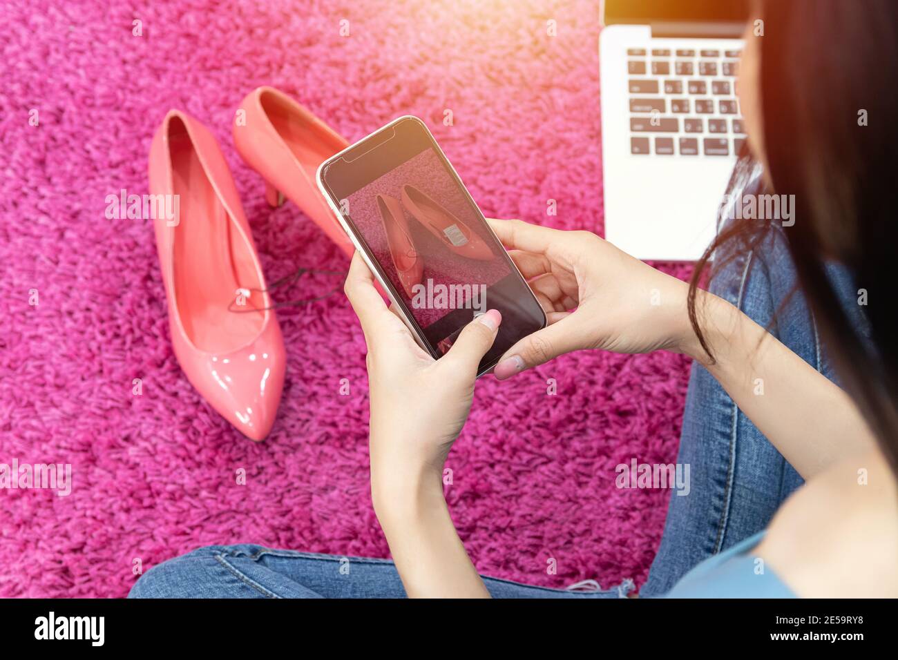 venta de idea en línea concepto. vendedor en línea utilizar teléfono móvil tomar una foto de zapatos de tacón alto para subir a la tienda de compras en línea sitio web. Foto de stock