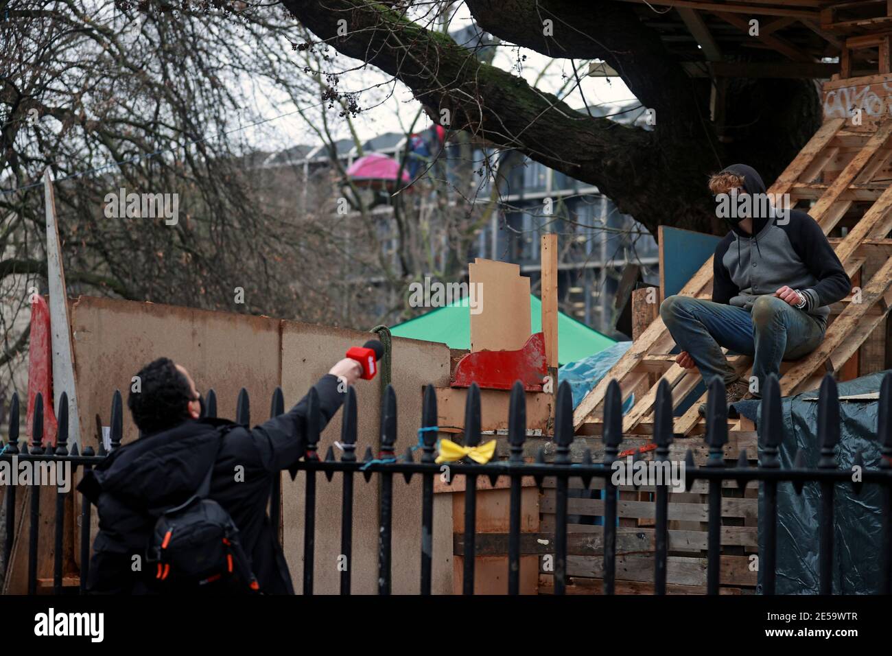 Un activista de la rebelión de extinción habla con un reportero en un campamento improvisado mientras otros ocupan túneles bajo Euston Square Gardens para protestar contra el ferrocarril de alta velocidad HS2 en Londres, Gran Bretaña, el 27 de enero de 2021. REUTERS/Hannah McKay Foto de stock