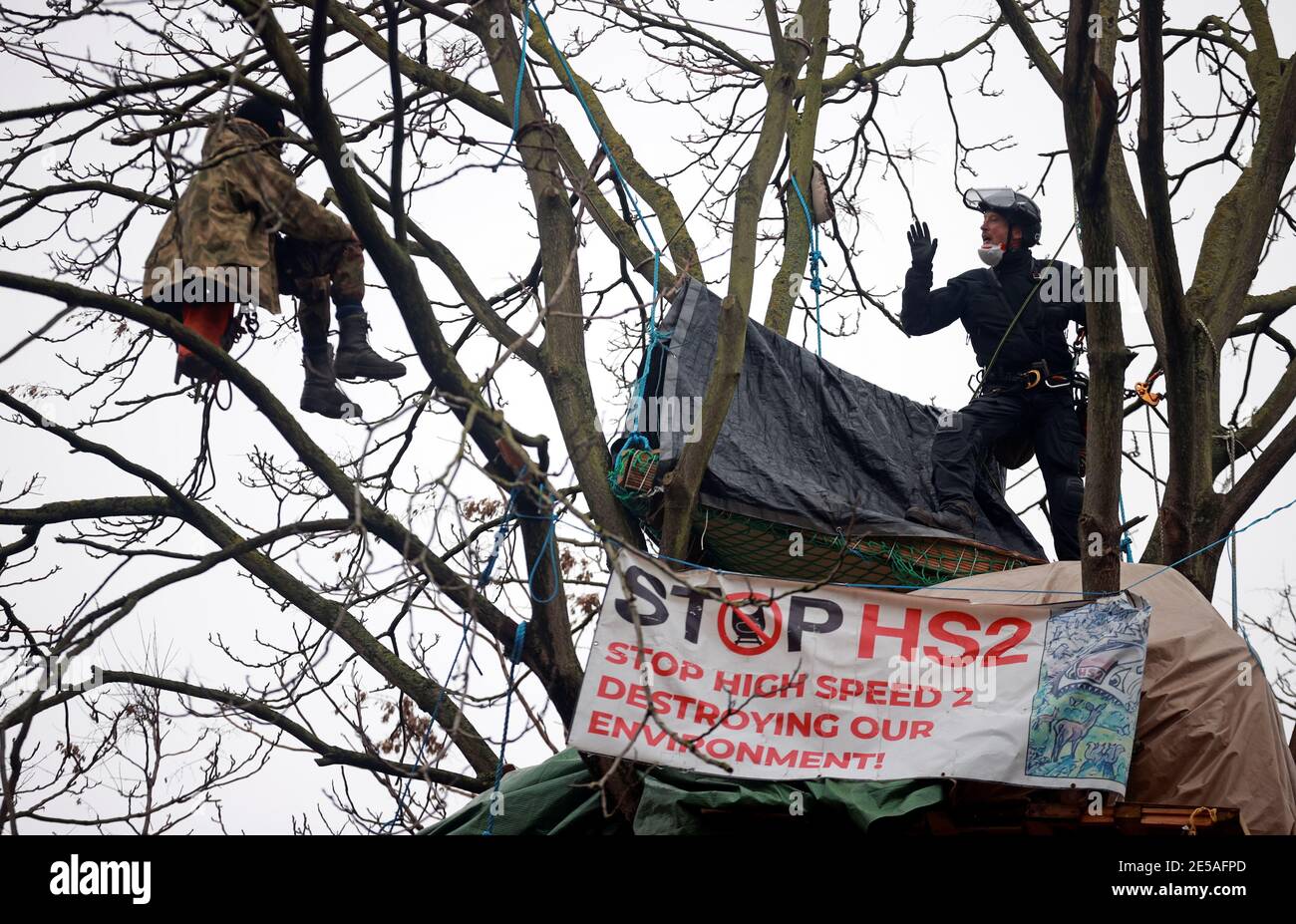 Un agente de la policía habla con un activista de extinción Rebelión que se manifiesta en un árbol mientras otros ocupan túneles bajo Euston Square Gardens, para protestar contra el ferrocarril de alta velocidad HS2 en Londres, Gran Bretaña, el 27 de enero de 2021. REUTERS/Hannah McKay Foto de stock