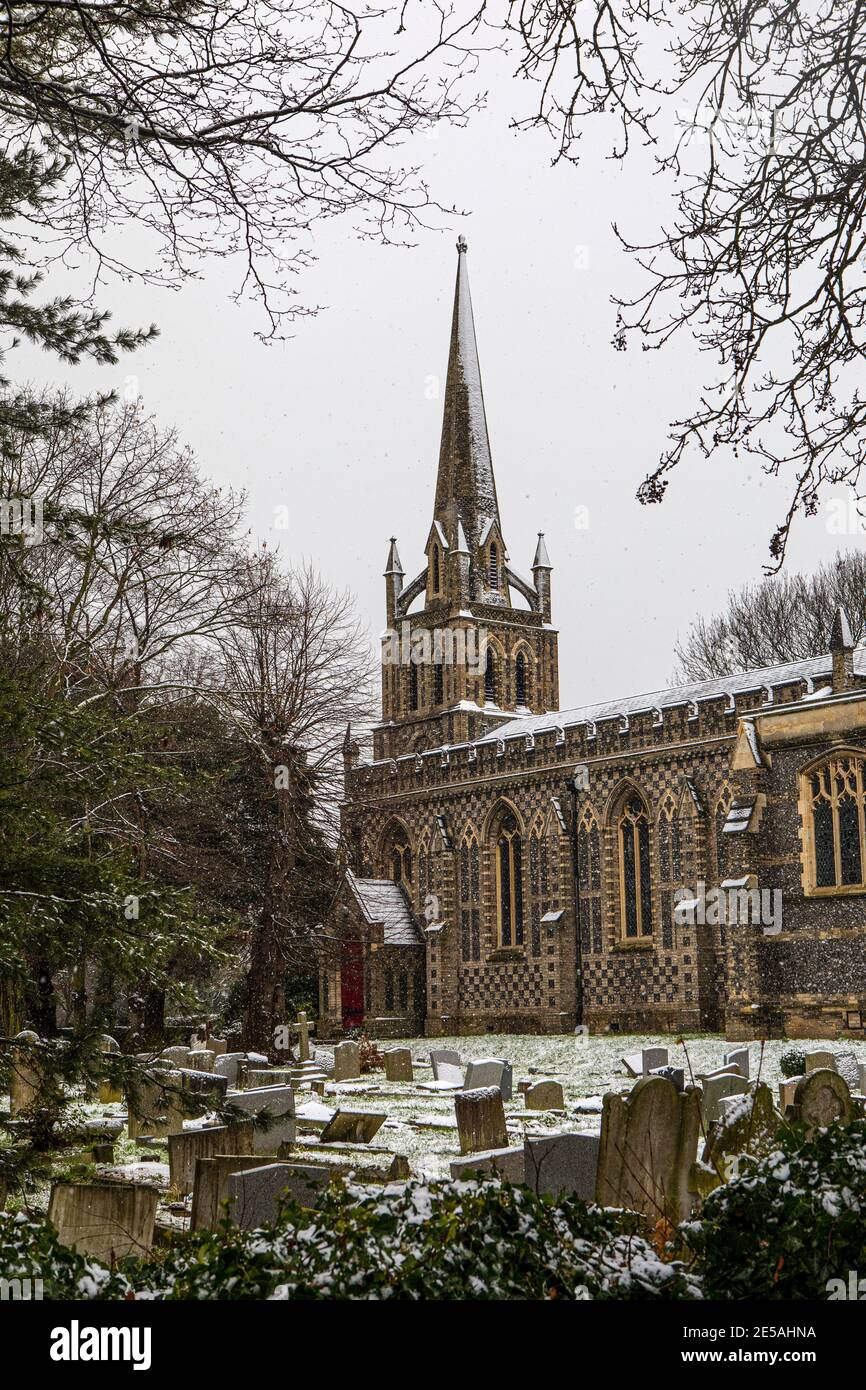 Una vista invernal de la nieve cayendo en la Iglesia de San Pedro y San Pablo en la ciudad de Chingford en Londres, Reino Unido. Foto de stock