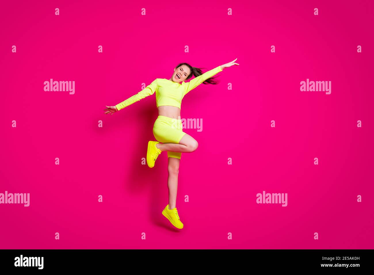 Foto a todo lo largo del tamaño del cuerpo de saltando deportista riendo  alegremente llevar ropa deportiva con estilo aislado sobre fondo de color  rosa brillante Fotografía de stock - Alamy