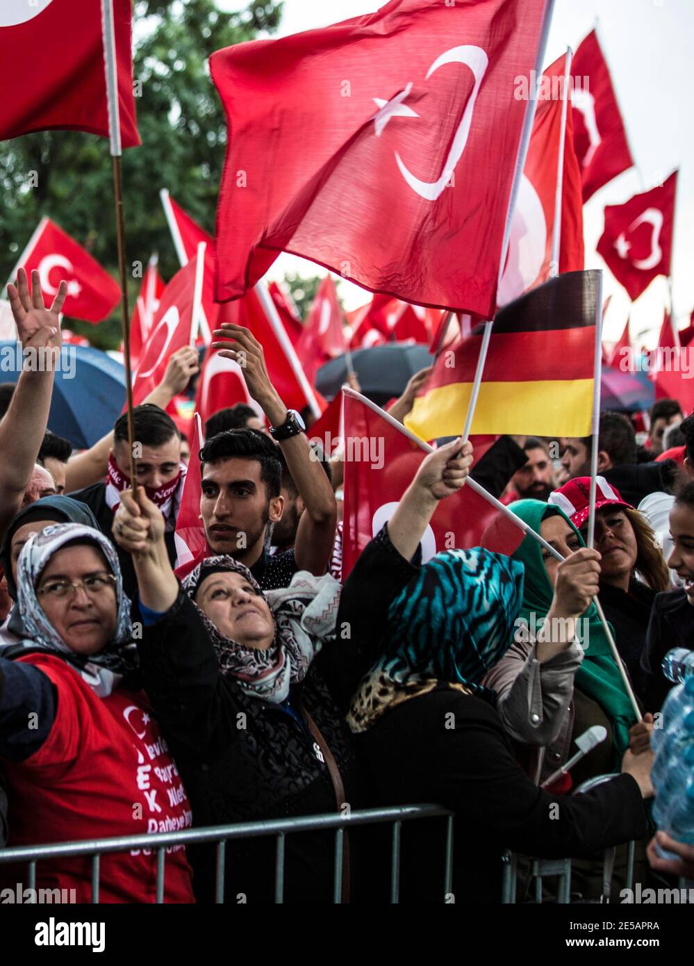 Ältere Frauen mit Kopftüchern schwenken türkische und deutscha Flaggen auf der Erdogan-demostración en Colonia. Im Hintergrund deutsch-türkische junge M Foto de stock