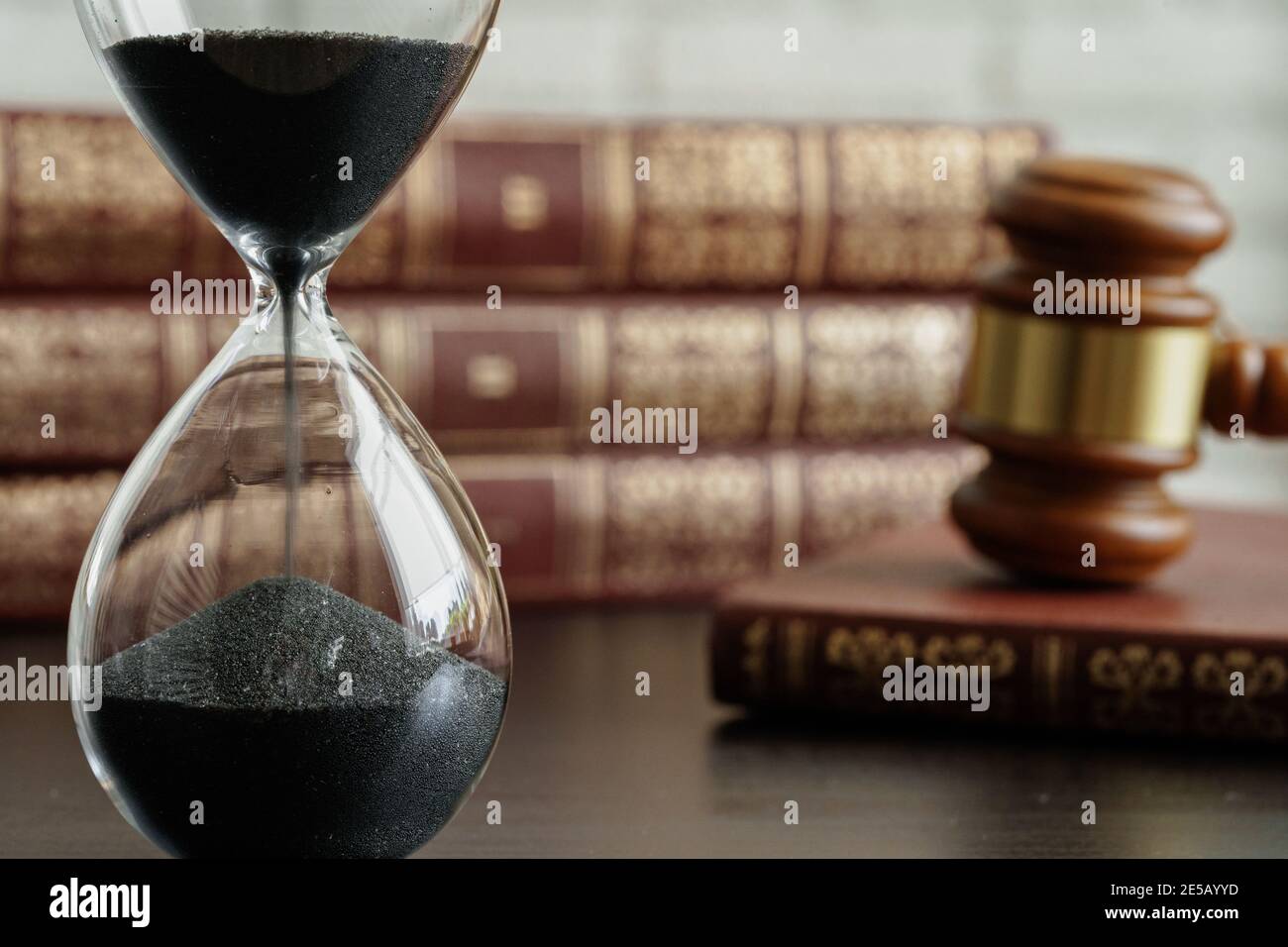 Concepto de tribunal. Reloj de arena y juez gavel en la mesa Foto de stock
