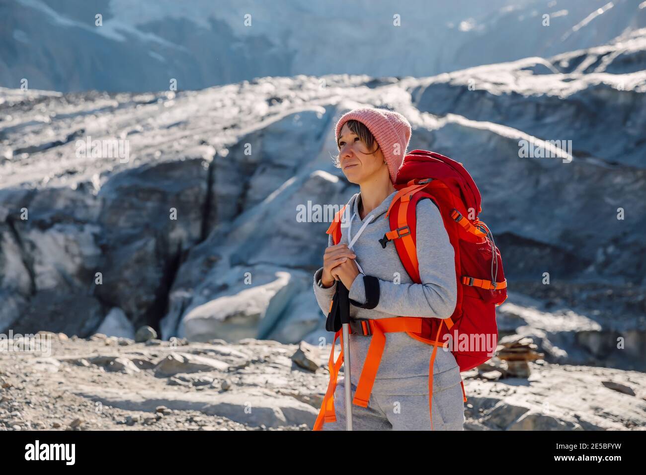 Mujer deportiva con mochila en las montañas. Montaña con glaciar y  turístico Fotografía de stock - Alamy