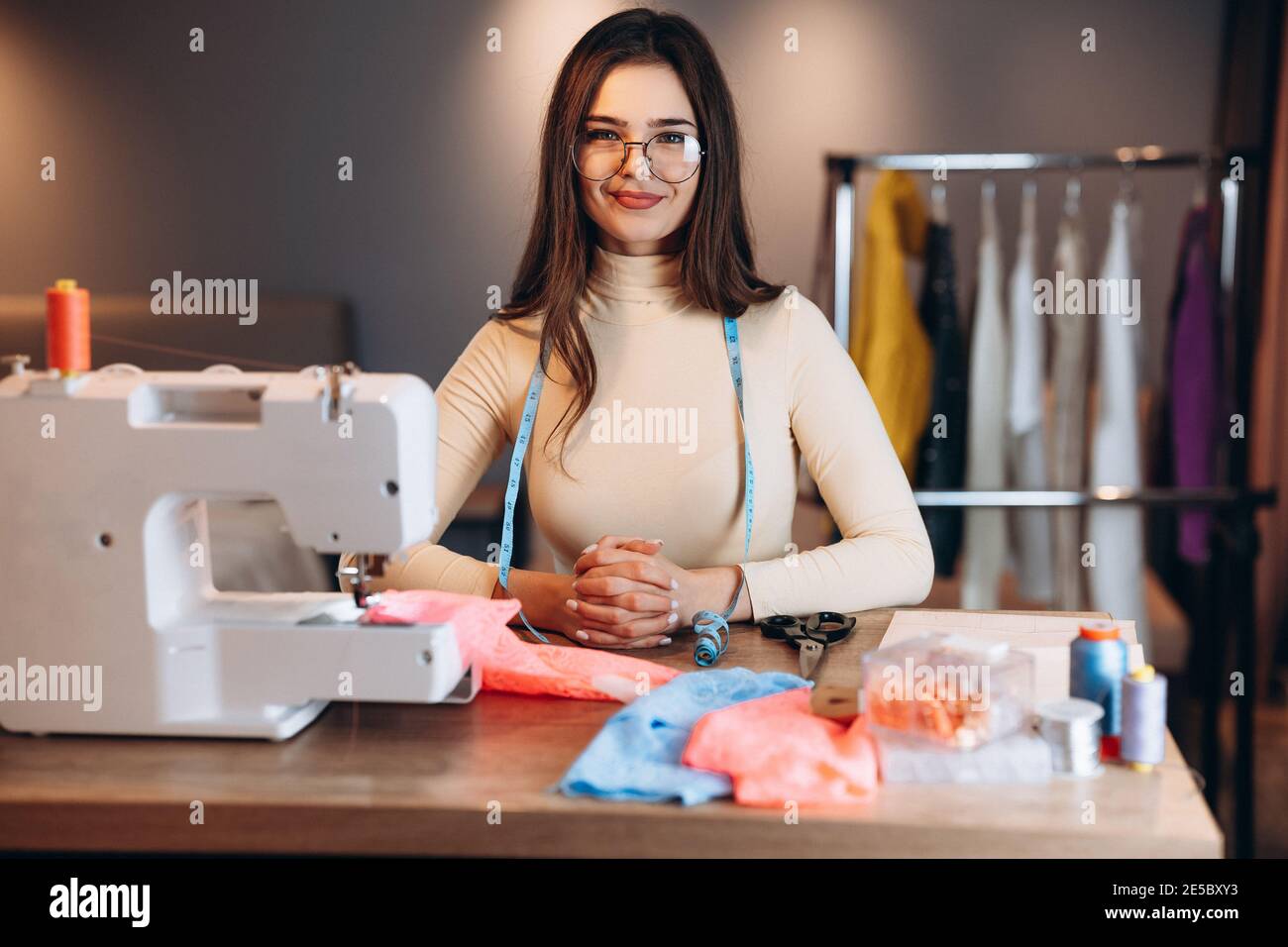 Bonita de la costura en los vasos sosa la ropa en la máquina de Sonriente costurera en el taller. Creación de cursos de diseño de ropa en Fotografía de