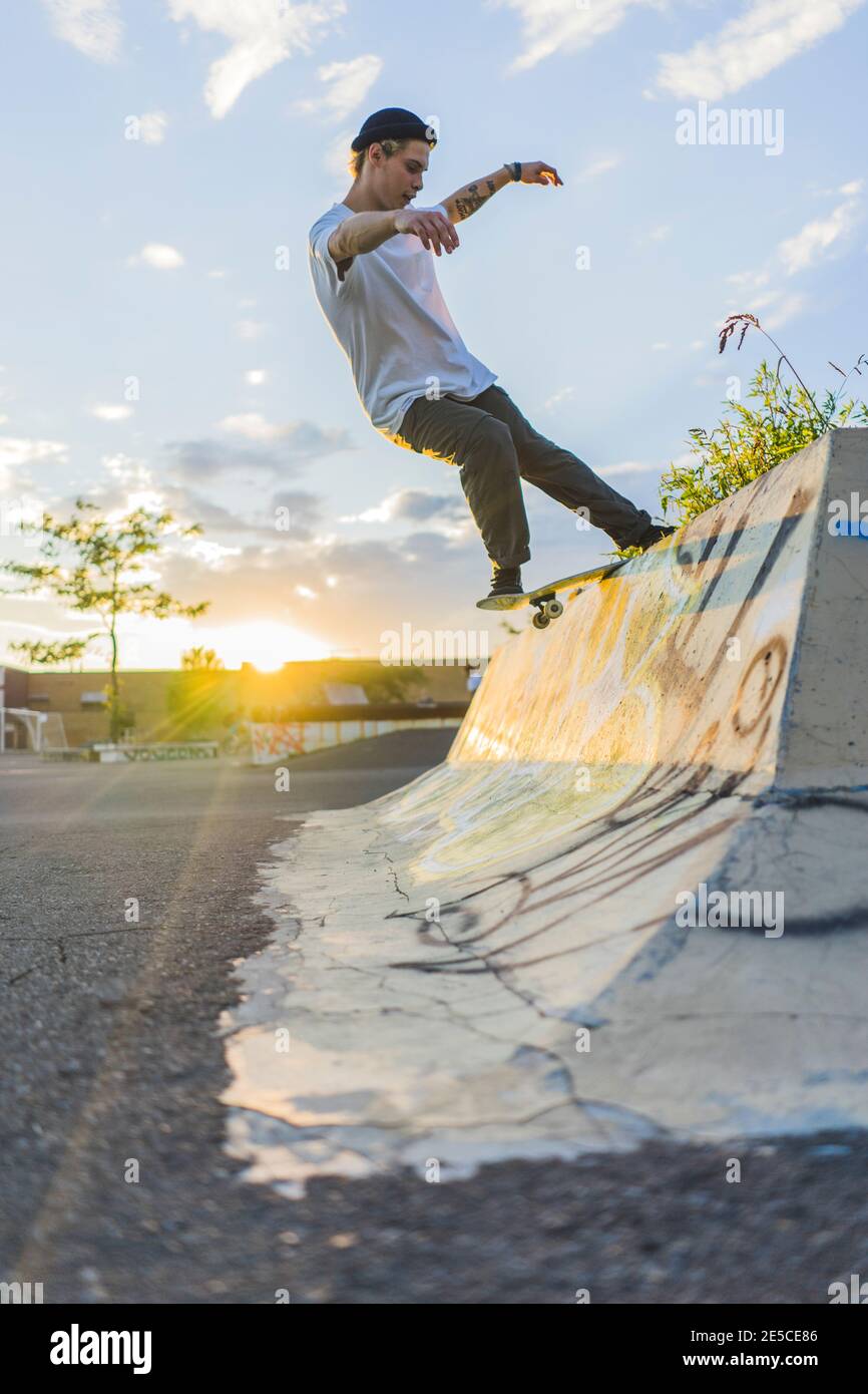 Atlético skateboarder adolescente haciendo un molido en skatepark, Montreal, Quebec, Canadá Foto de stock
