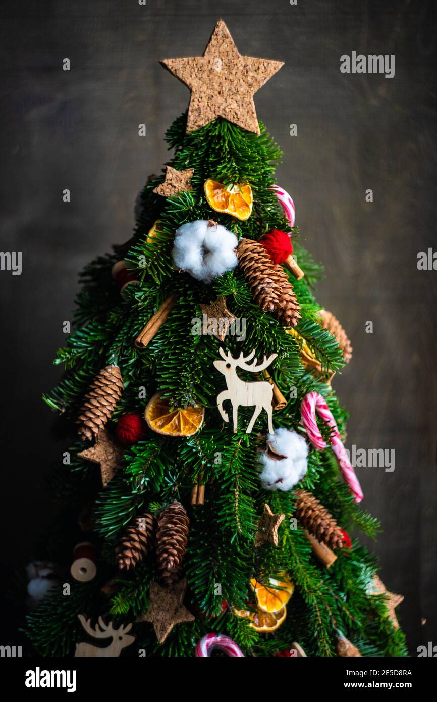 Corona de picea natural de Navidad con decoración seca, caña de pampas y  canela sobre fondo de madera Fotografía de stock - Alamy