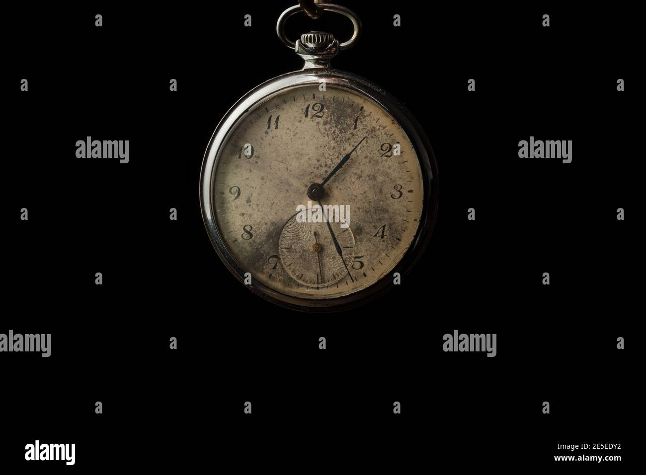 Viejo reloj de bolsillo de cadena sobre fondo negro Foto de stock