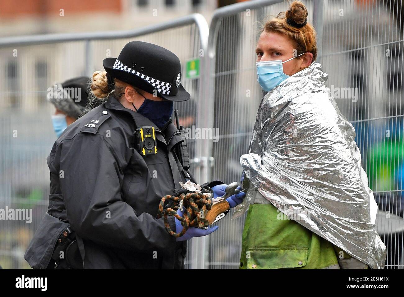 Un oficial de policía registra a un manifestante en un campamento improvisado, ya que los activistas de la rebelión de extinción ocupan túneles bajo Euston Square Gardens para protestar contra el ferrocarril de alta velocidad HS2, en Londres, Gran Bretaña, el 28 de enero de 2021. REUTERS/Toby Melville Foto de stock