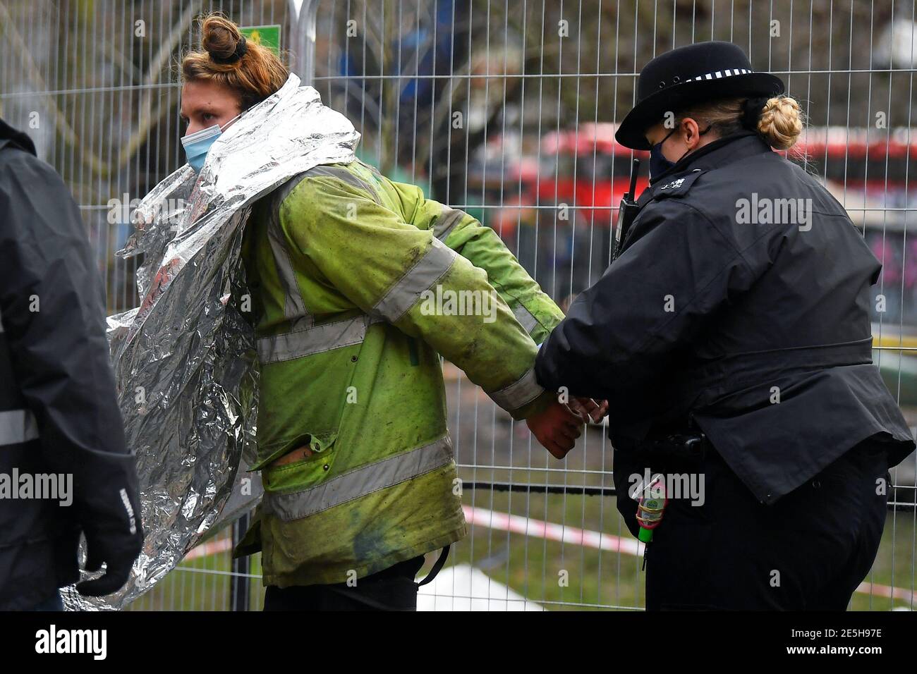 Un oficial de policía enana a un manifestante en un campamento improvisado, ya que los activistas de la rebelión de extinción ocupan túneles bajo Euston Square Gardens para protestar contra el ferrocarril de alta velocidad HS2, en Londres, Gran Bretaña, el 28 de enero de 2021. REUTERS/Toby Melville Foto de stock