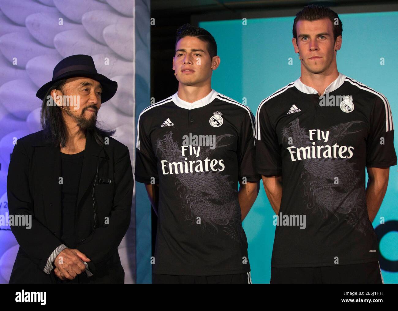 Real Madrid's Gareth Bale (R) and James pose along with Japanese designer Yohji (L) during the launching ceremony of the team's new UEFA Champions League kit at Santiago Bernabeu stadium