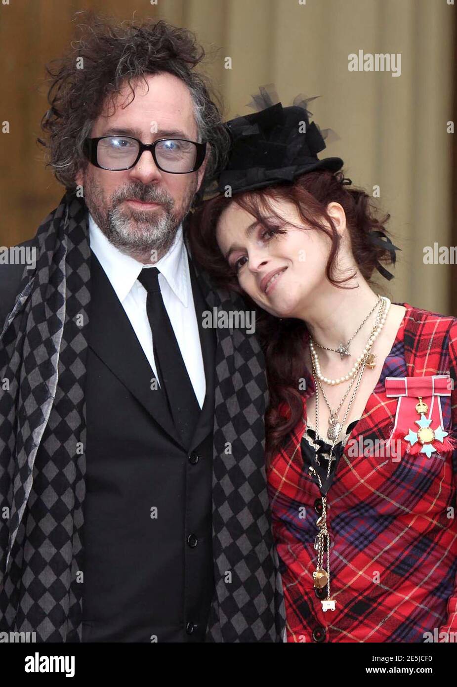 Actress Helena Bonham Carter,and her husband Tim Burton, pose with her  Commander of the British Empire (CBE) medal, after an Investiture ceremony  at Buckingham Palace in central London February 22, 2012. REUTERS/Sean