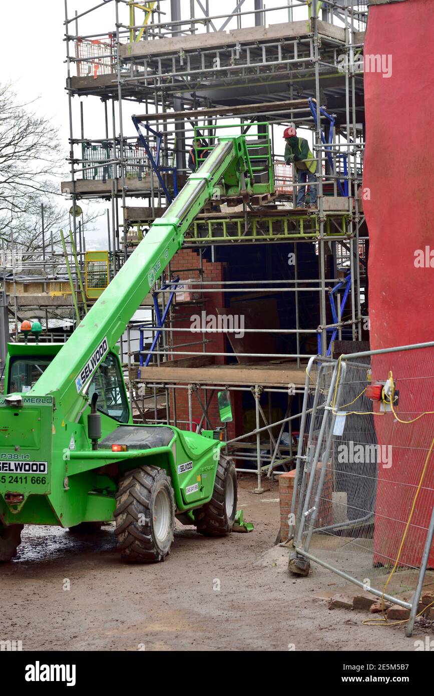 Vehículo de carretilla elevadora con grúa telescópica elevación entrega de bloques de hormigón en el sitio de construcción Foto de stock
