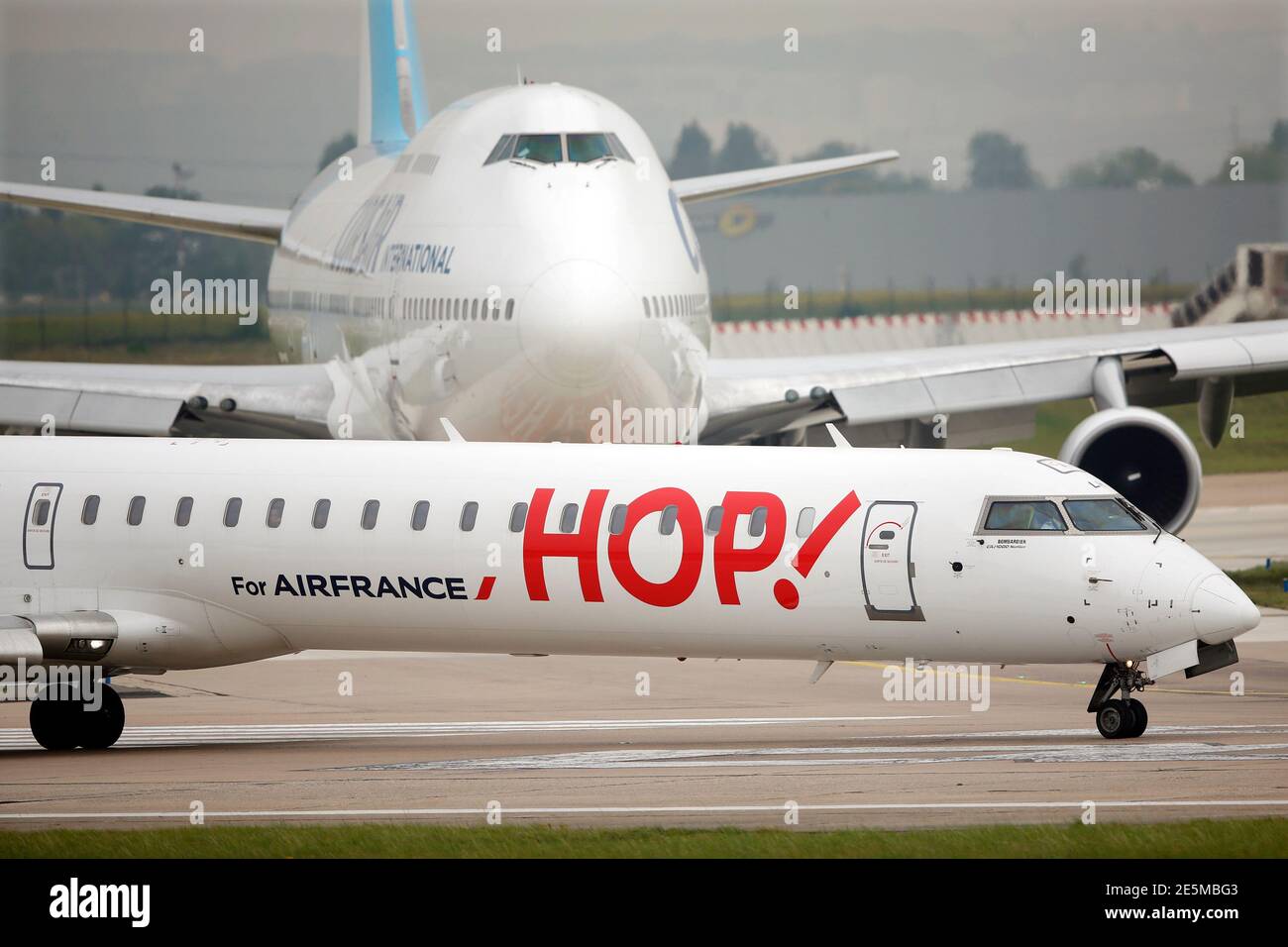 A Bombardier CRJ1000 of French regional airline unit Hop! (Front) and a  Corsair Boeing 747 passenger jet make their way on the tarmac before taking  off at Orly airport, near Paris, August