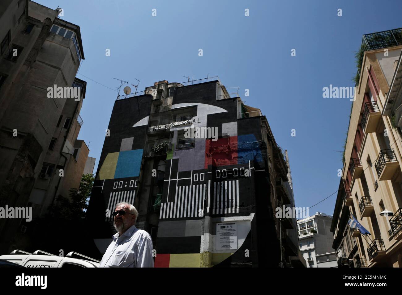 A man walks in front of a graffiti depicting a TV screen with no signal in  central Athens June 26, 2013. A year after coming to power, Prime Minister  Antonis Samaras suffered