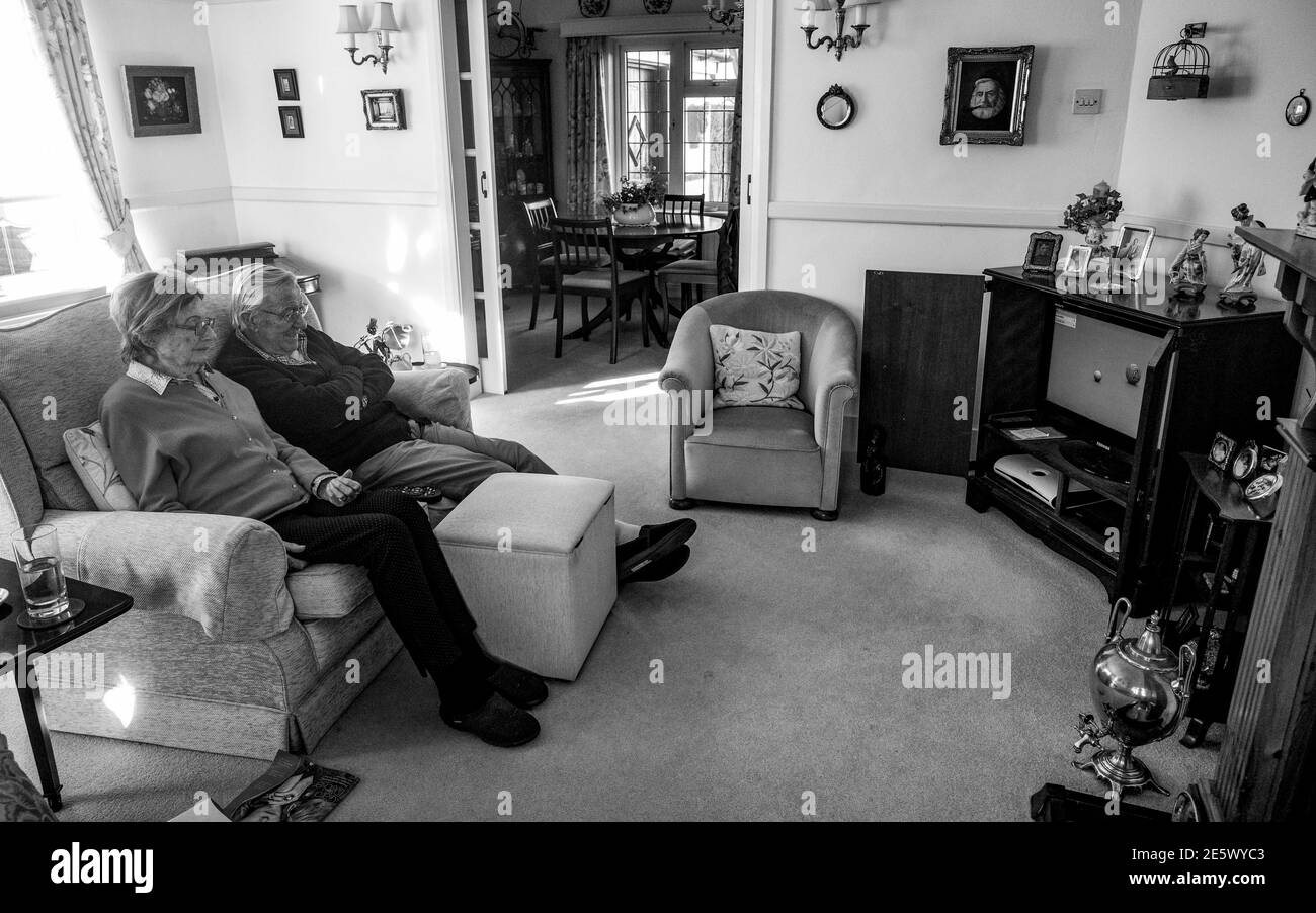 Pareja de ancianos en sus 80 viendo los tazones en la televisión Su sala de estar durante el cierre fotografía tomada por Simon Dack Foto de stock