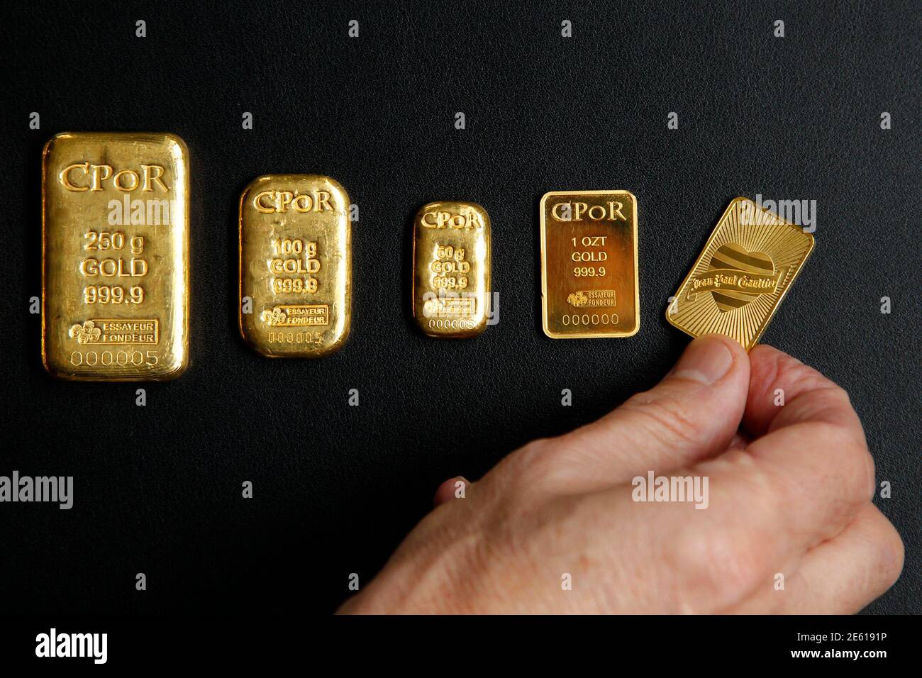 Un empleado muestra una barra de oro de gramo de una onza (R) diseñada por  el diseñador de moda Jean Paul Gaultier con barras de oro que pesan entre una  onza y