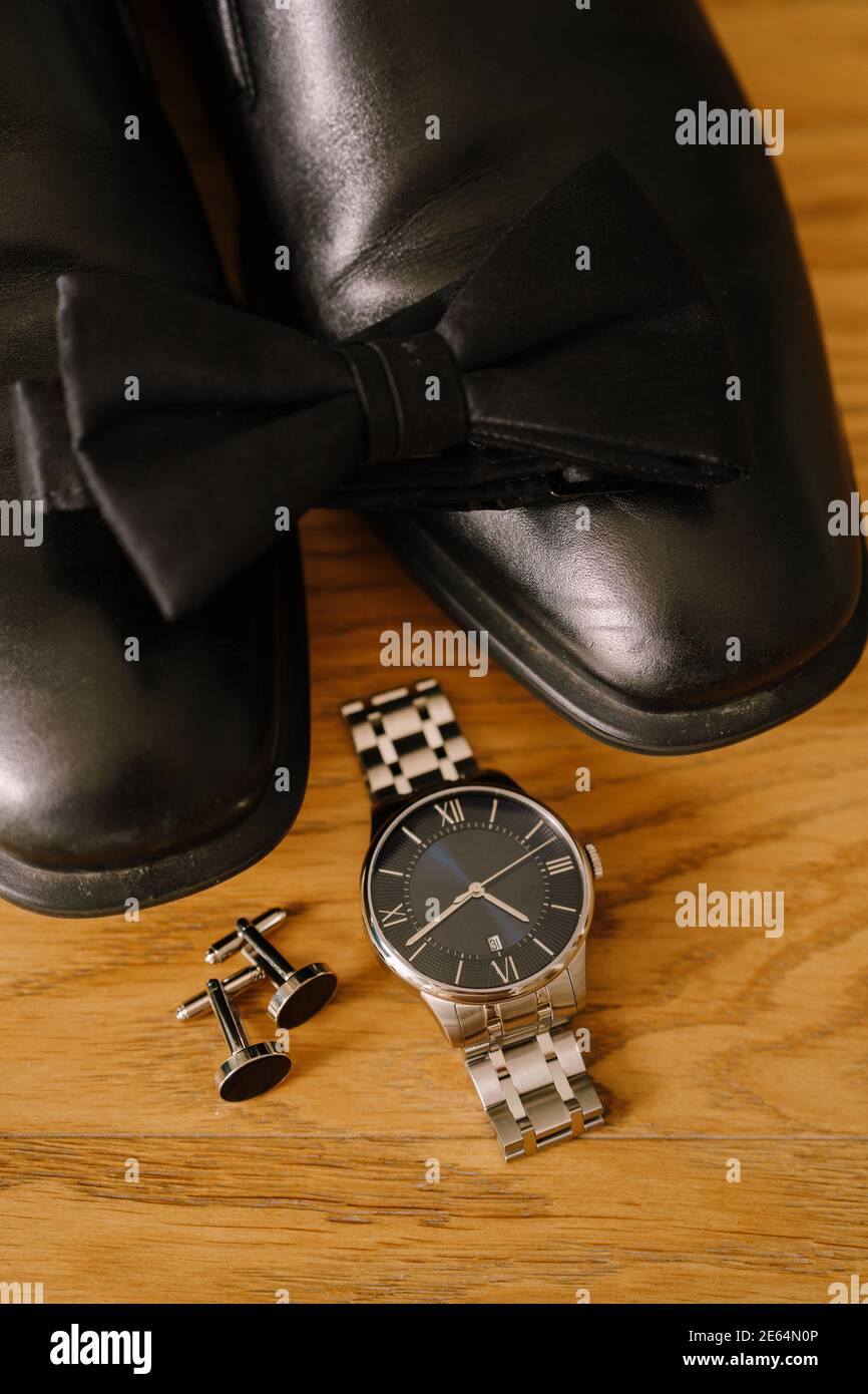 Lazo negro en zapatos para hombre con reloj de pulsera y gemelos sobre  textura de madera Fotografía de stock - Alamy