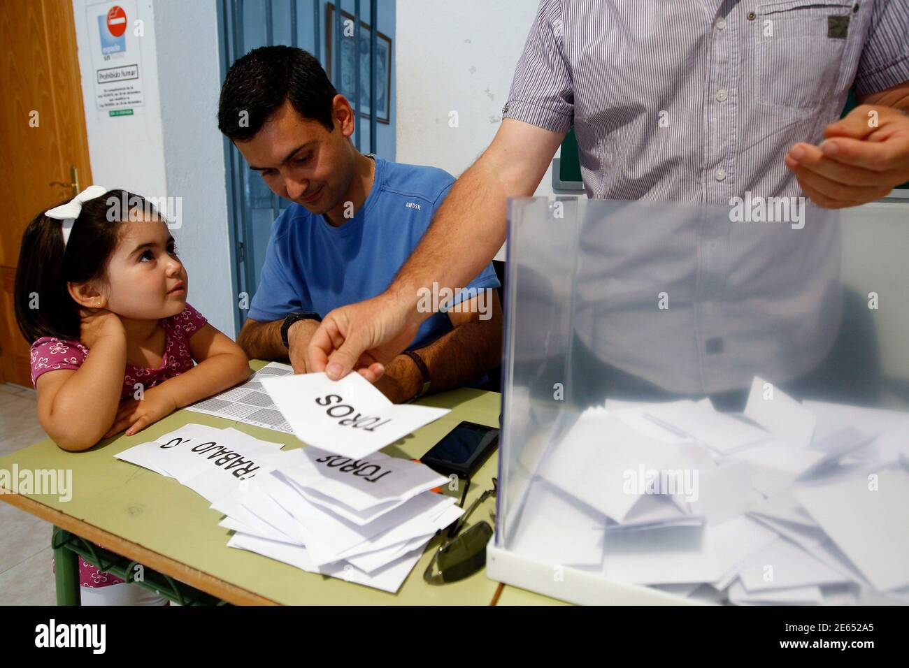 A girl watches mayor Javier Anton Garcia (C) and a town hall employee  counting ballots of the referendum at the Guijo de Galisteo village's main  square on the Spanish province of Extremadura