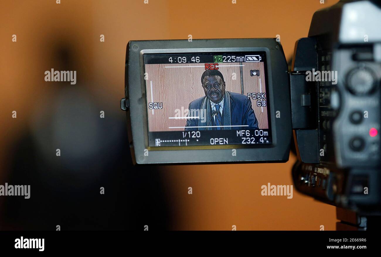 El ex presidente del club de fútbol del Olympique Marsella Pape Diouf es  visto en la pantalla de video de una cámara mientras anuncia su candidatura  para las próximas elecciones municipales en