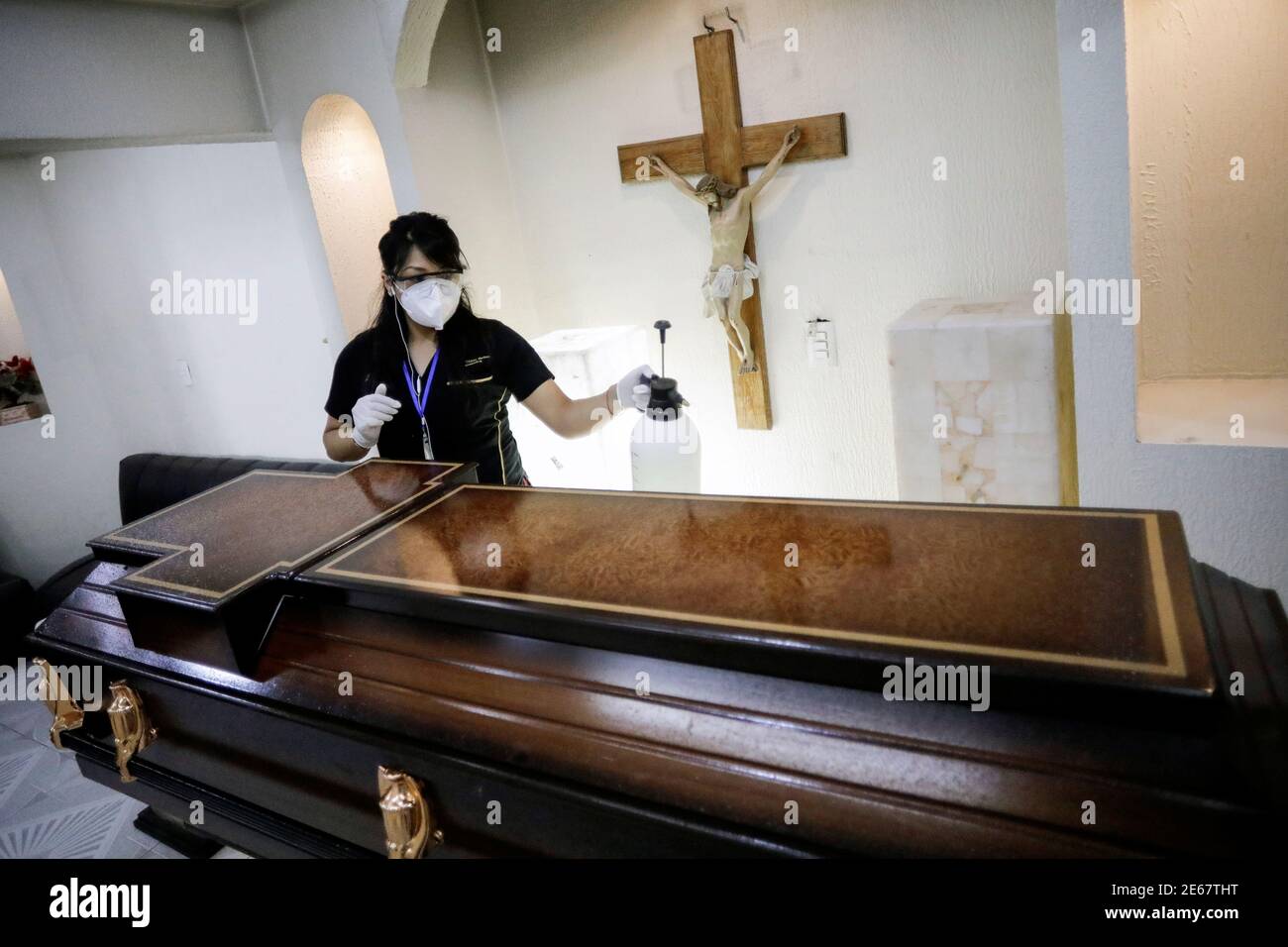 Un empleado sanea un ataúd en la capilla de una funeraria que contiene el  cuerpo de una persona que murió de la enfermedad del coronavirus  (COVID-19), en medio del brote de COVID-19,