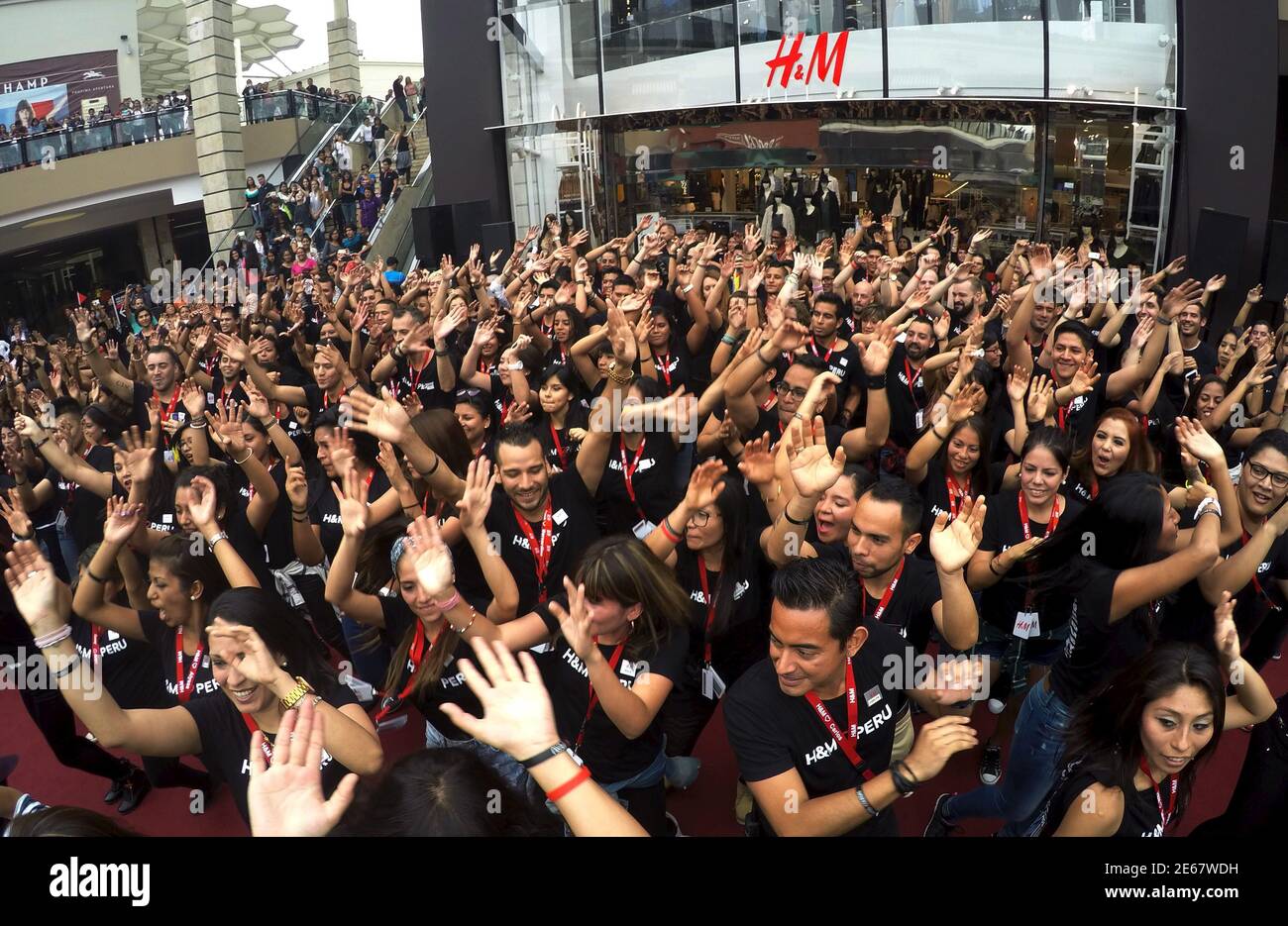 Trabajadores de Hennes & Mauritz (H&M) celebran fuera de la tienda durante  la inauguración de la primera tienda H&M en Perú, en el centro comercial  Jockey Plaza en Lima, 9 de mayo
