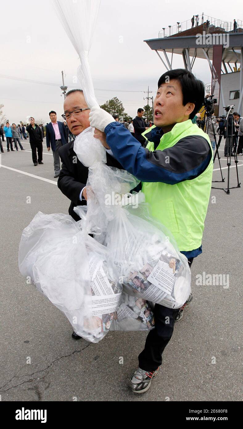 Park Sang-hak (R), un ex desertor norcoreano líder anti-Kim Jong-il eventos de folletos en el sur, se prepara para lanzar un globo que lleva volantes anti-Corea del Norte hacia el norte en el pabellón de Imjingak cerca de la zona desmilitarizada que separa las dos Coreas en Pajulu, a unos 55 km (34 millas) al norte de Seúl, 29 de abril de 2011. Los activistas lanzaron alrededor de 200,000 folletos anti-Pyongyang, DVD anti-Corea del Norte, radios y 1,000 billetes de un dólar el viernes. El líder norcoreano Kim Jong-il está dispuesto a mantener conversaciones directas con Corea del Sur, pero el estado aislado no se disculpará por dos mortíferos Foto de stock