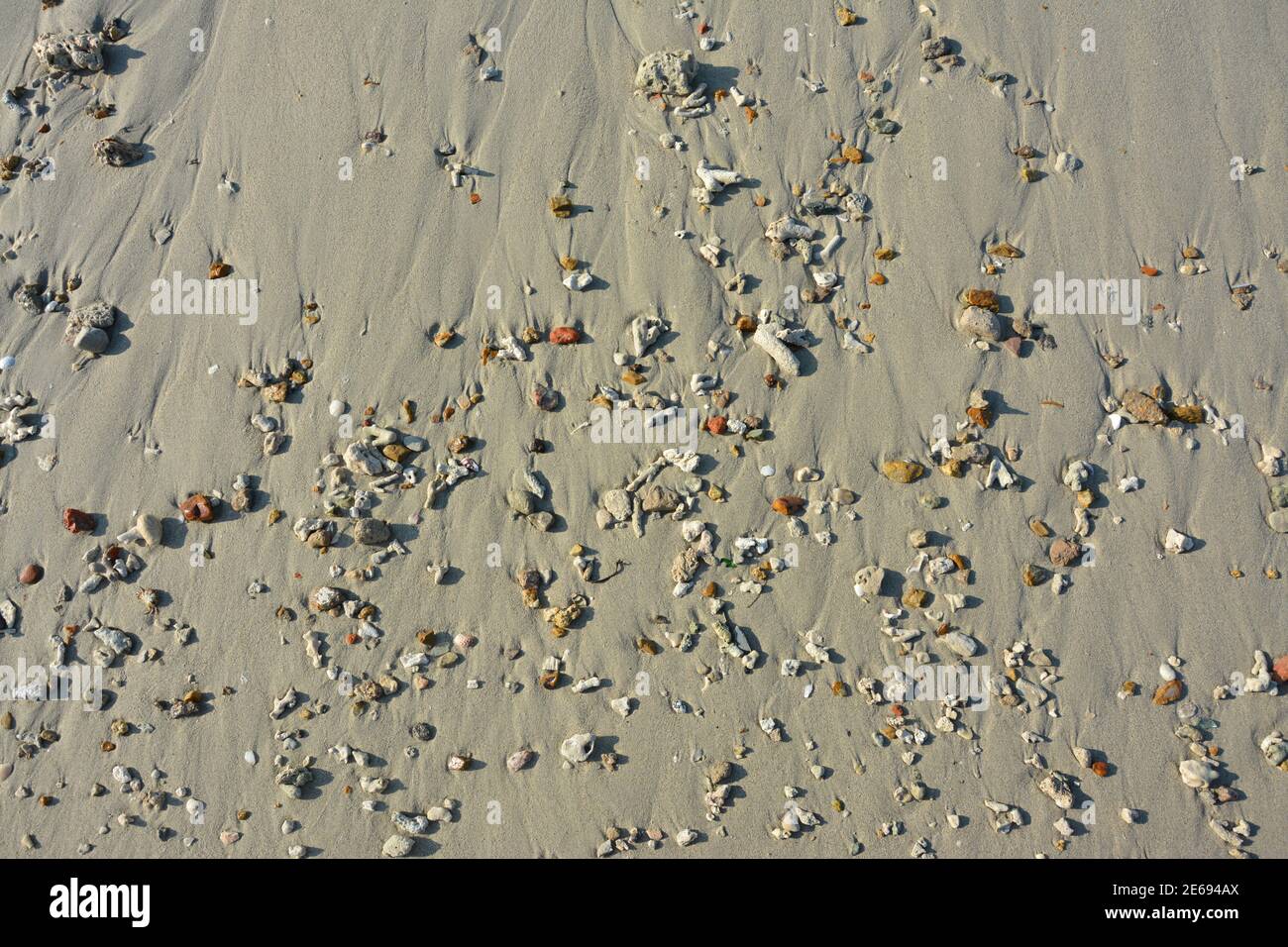 grupos de pequeñas rocas en la playa de arena en sol día Foto de stock