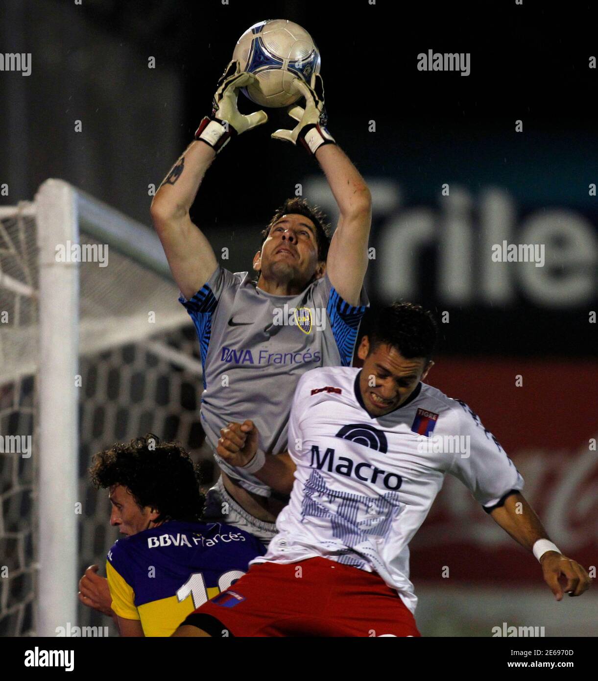 Boca Juniors' goalkeeper Agustin Orion (C) catches the ball next to  teammate Pablo Ledesma (L) and under pressure from Tigre's Matias Escobar  during their Argentine First Division soccer match in Buenos Aires