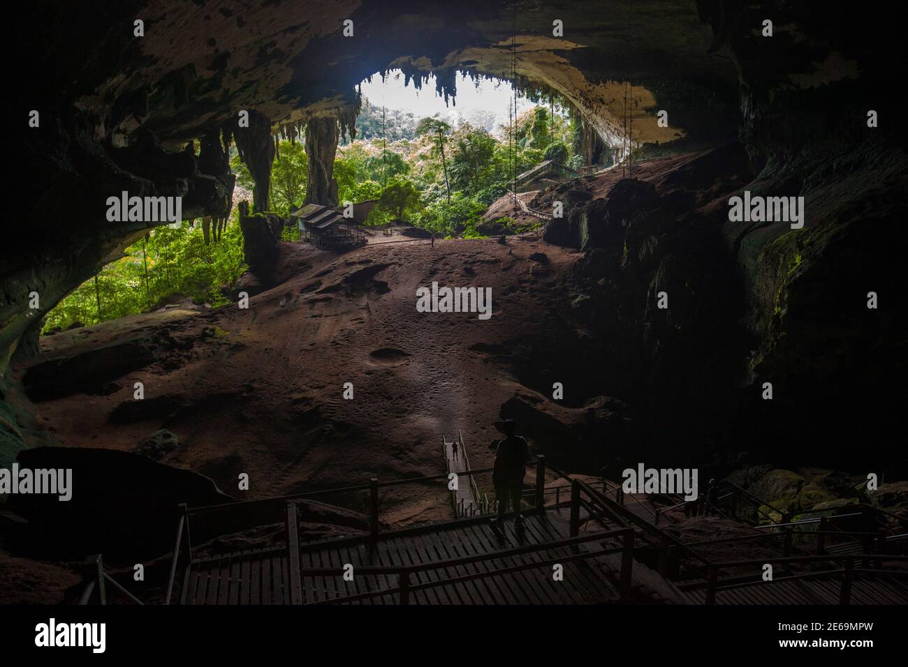 Los turistas ven la entrada principal de la Gran Cueva de Niah en el Parque Nacional de Niah, en el estado malayo de Sarawak en la isla de Borneo, 29 de marzo de 2012. Las cuevas de NIAH contienen los restos más antiguos del Homo sapiens que se encuentran en Borneo, y cuenta con la entrada de la cueva de piedra caliza más grande del mundo, así como pinturas rupestres antiguas. Estudios publicados recientemente han demostrado evidencia de la primera actividad humana en las cuevas de Niah de California. 46,000 a aprox. hace 34,000 años. Foto tomada el 29 de marzo de 2012. REUTERS/David Loh (MALASIA - Tags: MEDIO AMBIENTE SOCIEDAD VIAJES) Foto de stock
