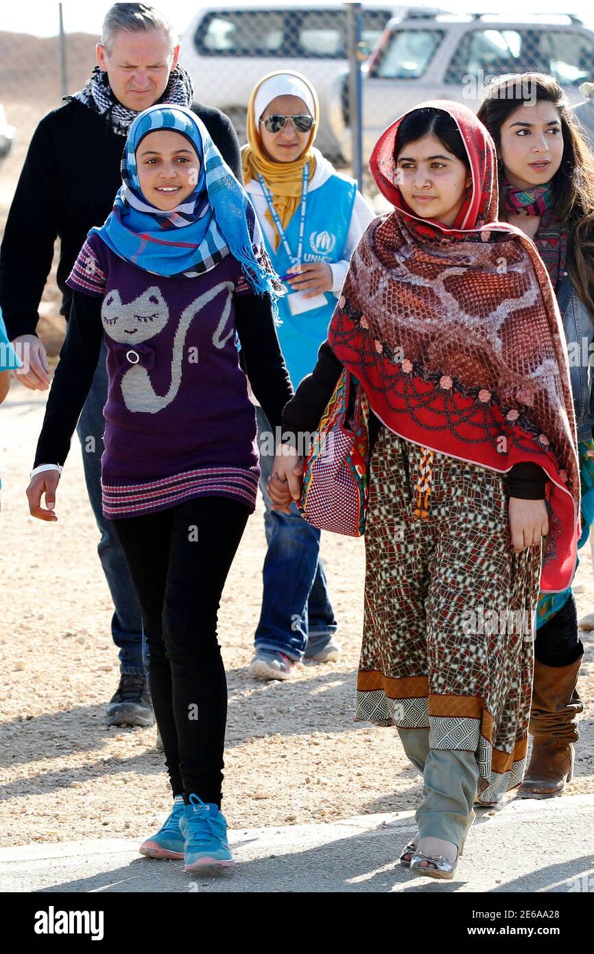 La activista adolescente paquistaní Malala Yousafzai (R) y el refugiado  sirio Mazoon Rakan (L), de 16 años, caminan en un centro de UNICEF para  visitar una galería de arte para niños, antes