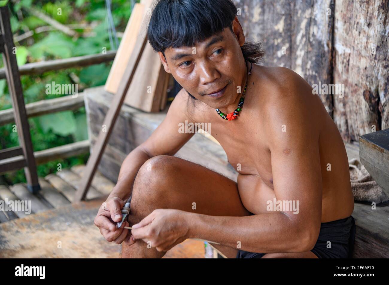Orang Ulu hombre haciendo dardos de golpe para la pistola de aire Foto de stock