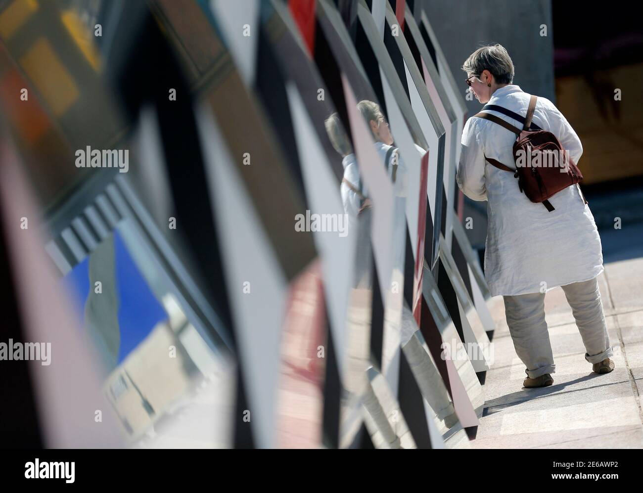 A visitor walks past a creation as part of the exhibition "Defini Fini Infini, Travaux in situ" by French artist Daniel Buren at the MaMo art center in Marseille September 12, 2014. The MaMo contemporary art center is installed on the restored rooftop terrace of Le Corbusier's 1947 Cite Radieuse (Radiant City) and created by French designer Ora-Ito. The exhibition will run until September 30, 2014. REUTERS/Jean-Paul Pelissier (FRANCE - Tags: ENTERTAINMENT SOCIETY) Foto de stock