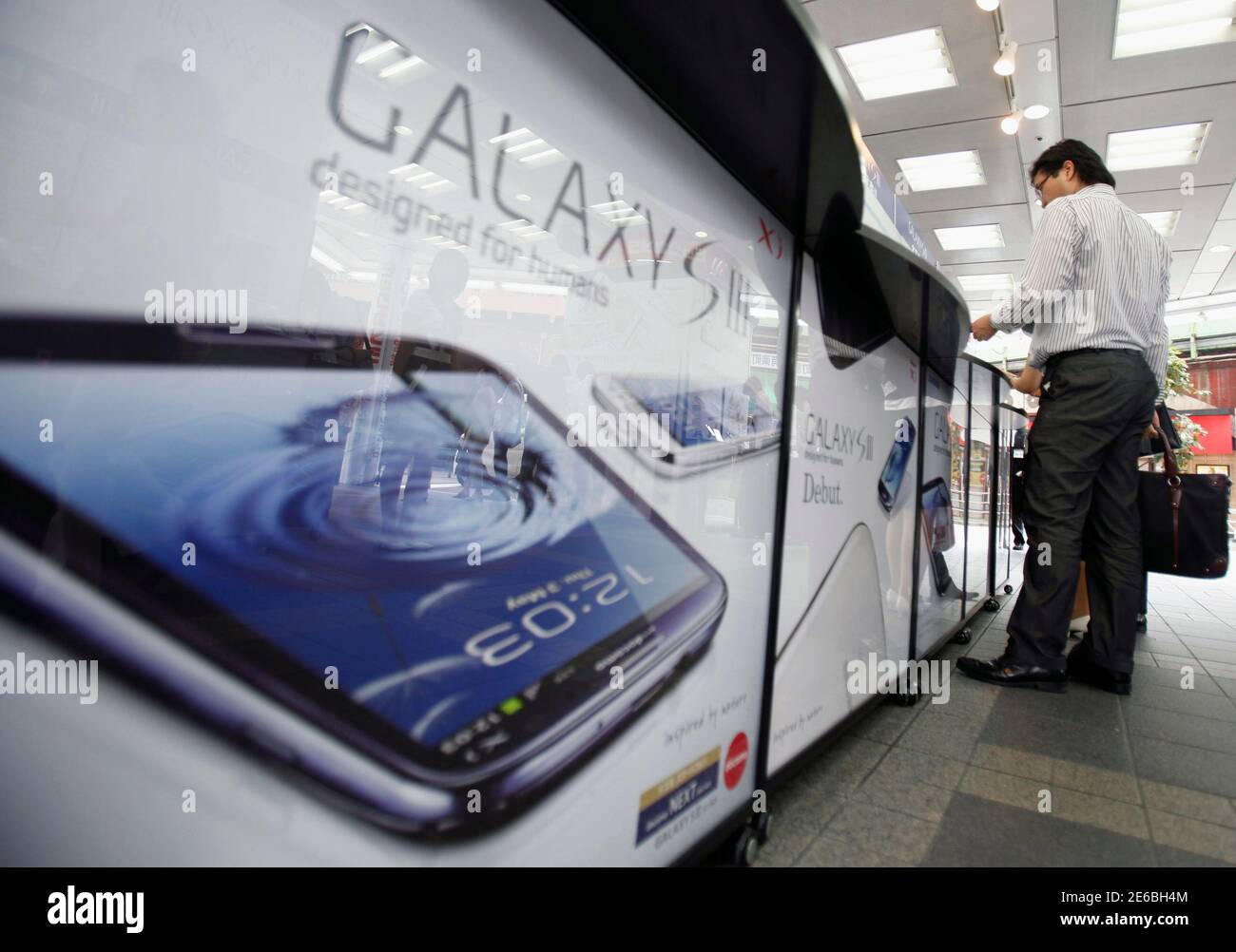 Un cliente prueba un smartphone Samsung Galaxy S III, lanzado por el mayor operador móvil de Japón NTT Docomo Inc, en una tienda de electrónica en Tokio el 28 de junio de 2012. El Galaxy S III ha recibido las críticas más positivas entre cualquiera de los smartphones Samsung, y el gigante de la tecnología dice que el teléfono está en camino de convertirse en su teléfono inteligente más rápido de venta, con las ventas probablemente a los 10 millones en los primeros dos meses desde su lanzamiento. REUTERS/Yuriko Nakao (JAPÓN - Tags: CIENCIA TECNOLOGÍA EMPRESA TELECOMUNICACIONES) Foto de stock