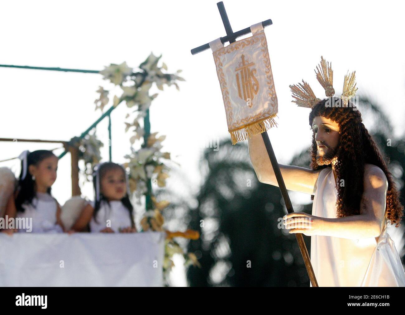 Los niños vestidos como ángeles miran una imagen de Cristo Resucitado  durante una procesión para celebrar la Fiesta de la Resurrección en el  amanecer del Domingo de Pascua, fuera de una iglesia