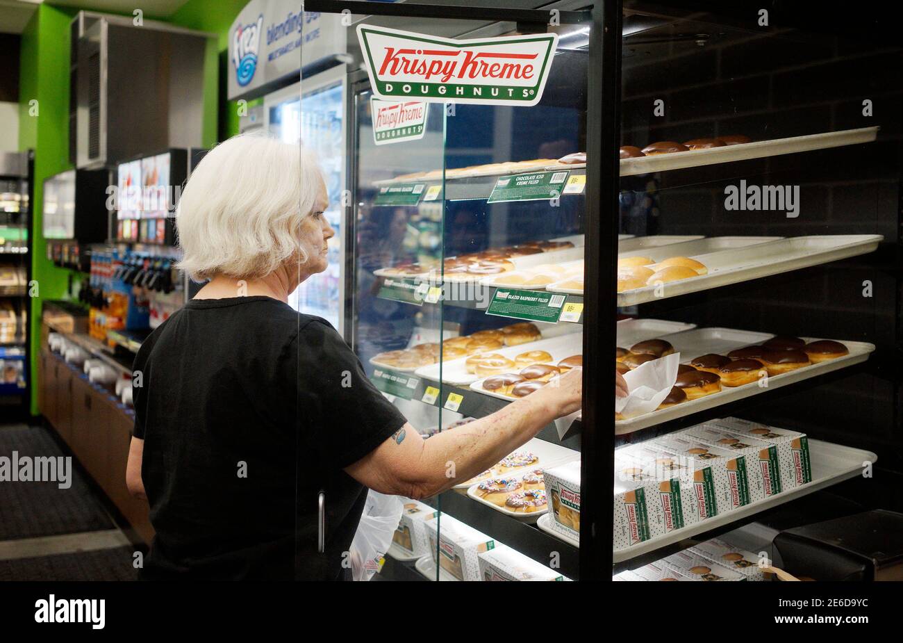 A customer buys Krispy Kreme doughnuts at a Walmart to Go convenience store  which is open on a trial basis in Bentonville, Arkansas June 5, 2014. The  new Walmart to Go stores