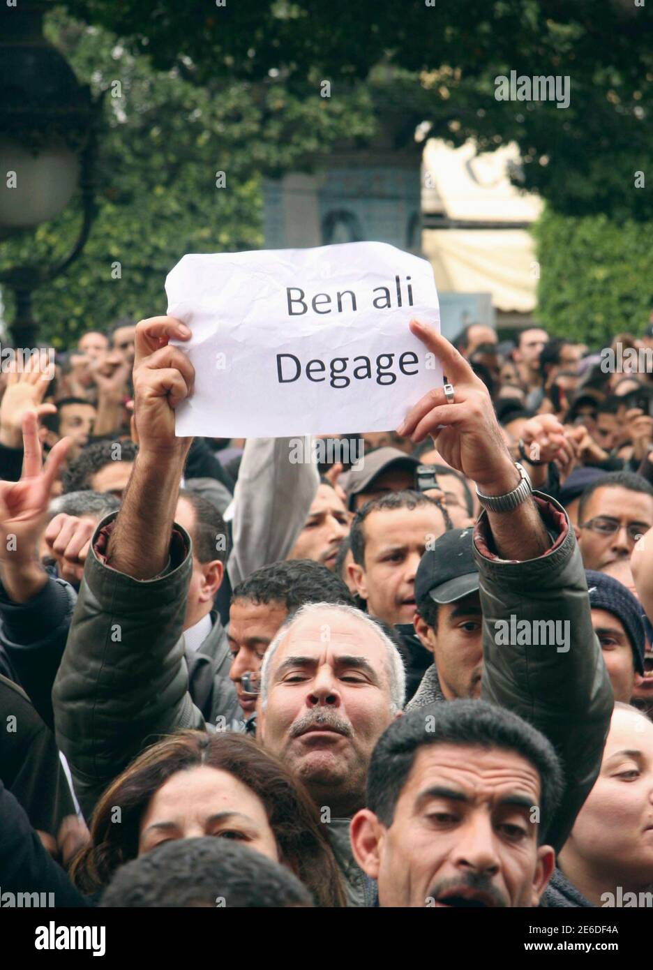 Los tunecinos gritan eslóganes mientras se manifiestan contra el presidente tunecino Zine al-Abidine Ben Ali en Túnez el 14 de enero, 2011 .los manifestantes exigieron la inmediata dimisión del presidente tunecino Zine al-Abidine Ben Ali el viernes, a pesar de la promesa del veterano gobernante de abandonar en 2014 en un intento por poner fin a los peores disturbios de su gobierno.al menos 5,000 personas se manifestaron fuera del ministerio del interior cantando "Ben Ali, ¡se van!" Y 'Ben Ali, gracias, pero eso es suficiente!", dijo un reportero de Reuters. El periódico dice 'Ben Ali, salir'. REUTERS/Zoubeir Souissi (TÚNEZ - Tags: POLÍTICA MILITAR DISTURBIOS CIVILES) Foto de stock