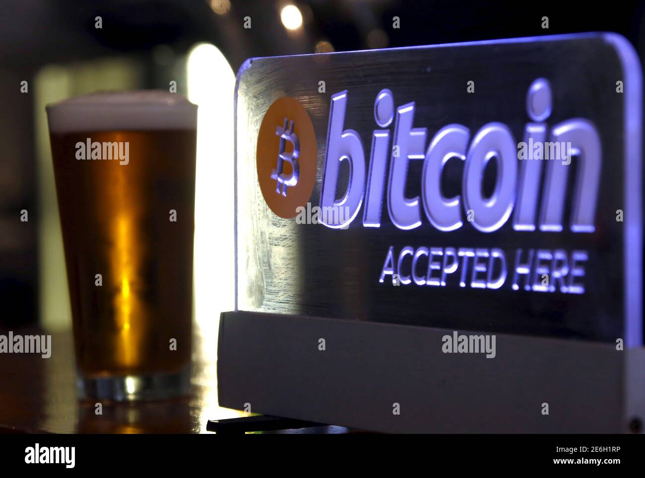 Una cerveza servida para un cliente se sienta en un bar junto a un cartel  de Bitcoin en el centro de Sydney, Australia, 29 de septiembre de 2015. Las empresas  australianas están