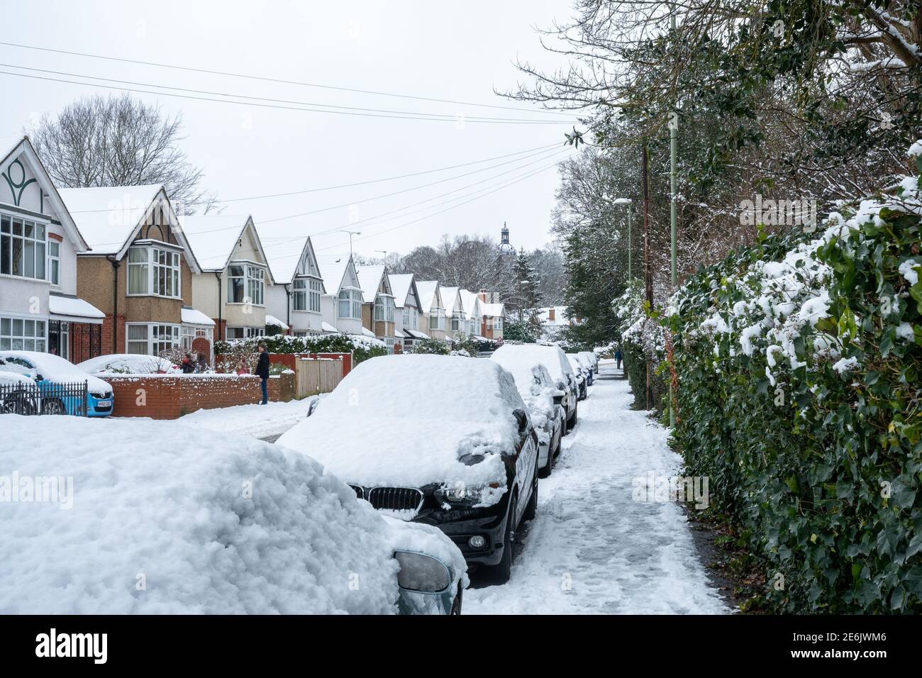 Casas y coches cubiertos de nieve en Highgate Lane, Farnborough, Hampshire, Reino Unido, en enero o invierno Foto de stock