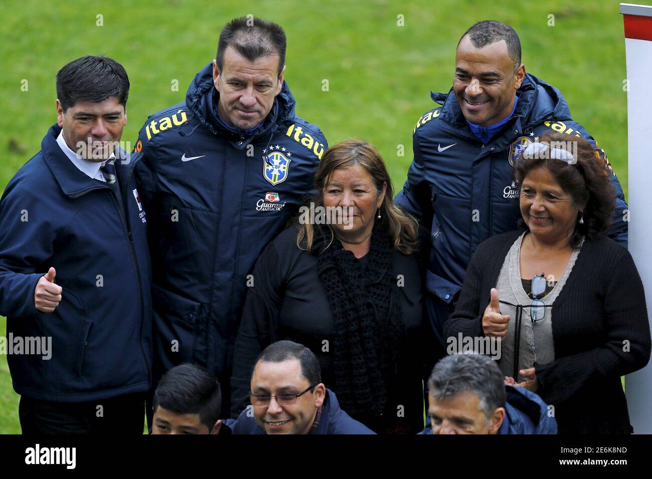 El entrenador principal de Brasil Dunga (2do L) y su asistente, el ex  jugador brasileño de fútbol Cafu (top R) posan con víctimas de un terremoto  después de una sesión de entrenamiento