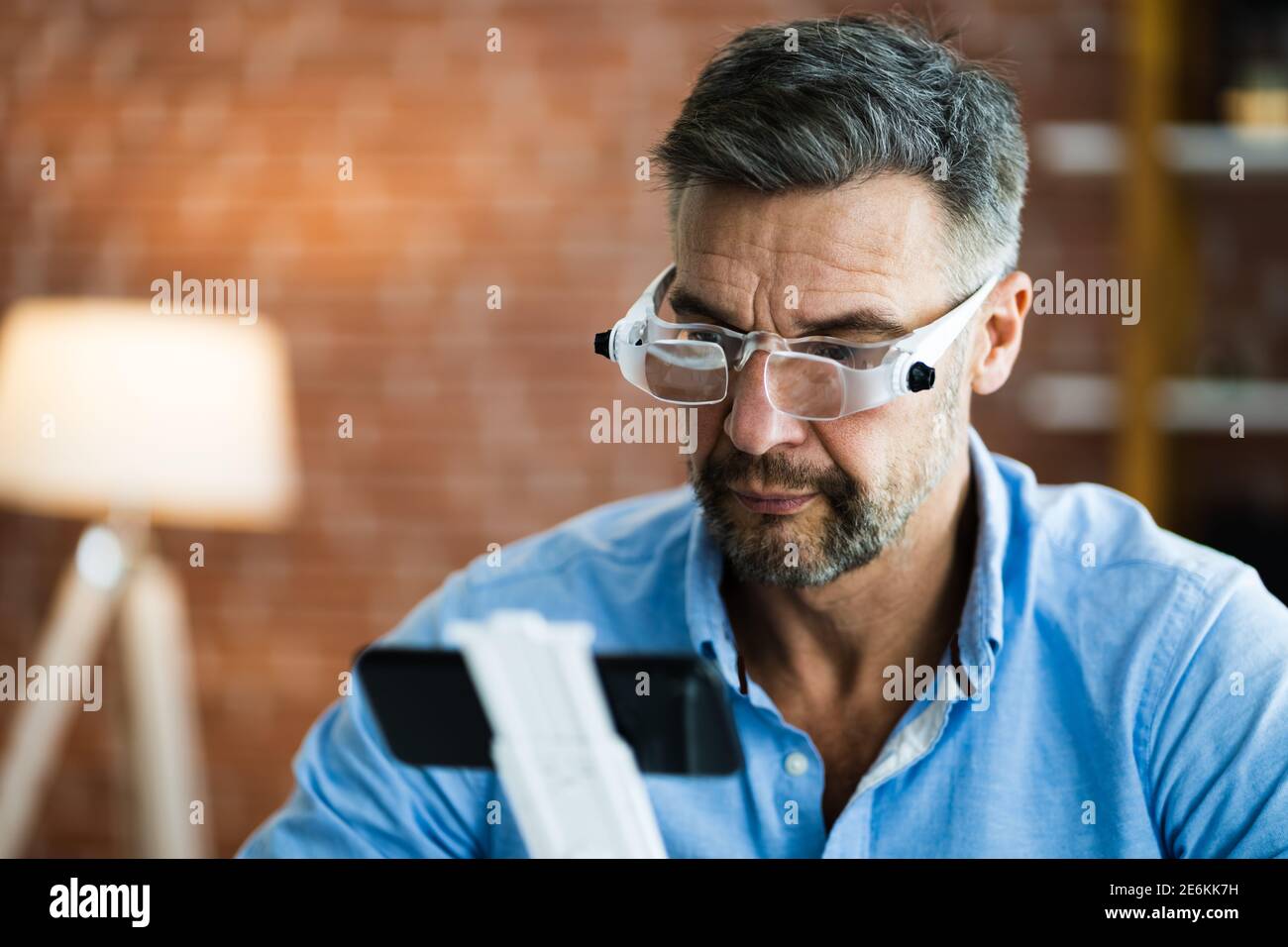 Hombre maduro con gafas de aumento para leer texto en el