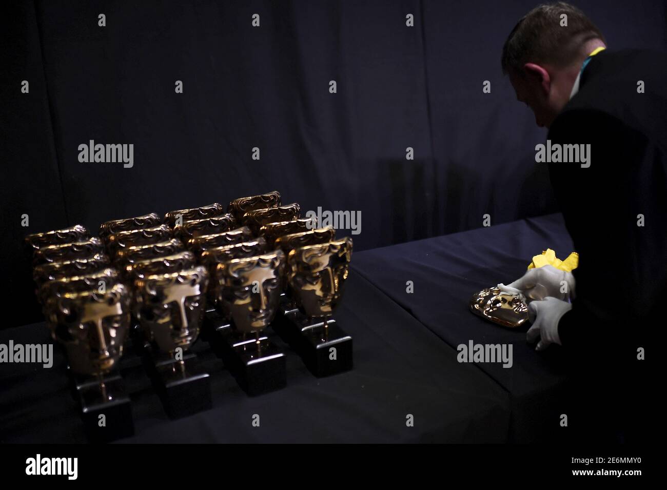 Un hombre pule un premio de máscara de bronce por delante de los premios de la Academia Británica de Artes del Cine y la Televisión (BAFTA) en la Royal Opera House de Londres, 14 de febrero de 2016. REUTERS/Dylan Martínez Foto de stock