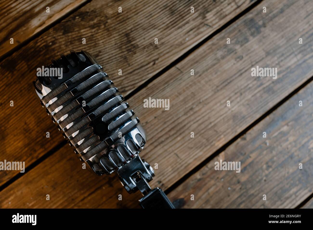 Micrófono retro sobre fondo de madera oscura con espacio de copia para texto Foto de stock